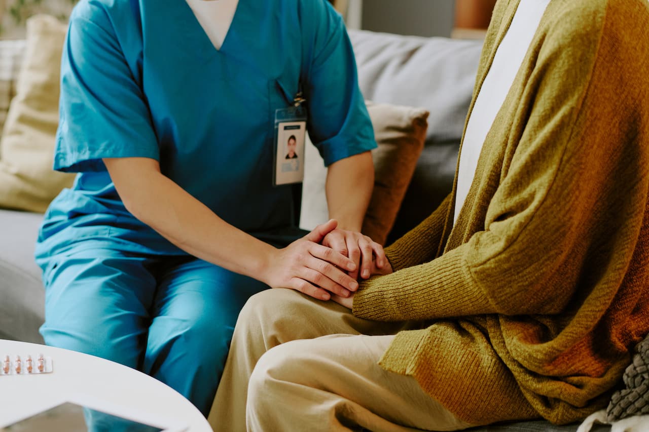 Supportive Healthcare Worker Holding Hands with Patient