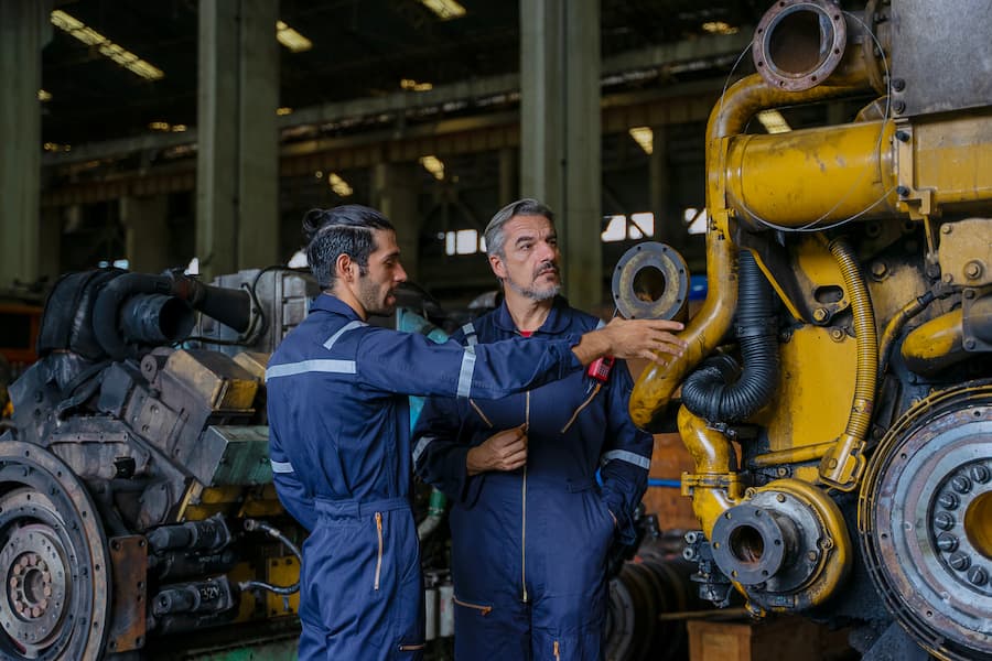 Technicians work at train engine repair shop.