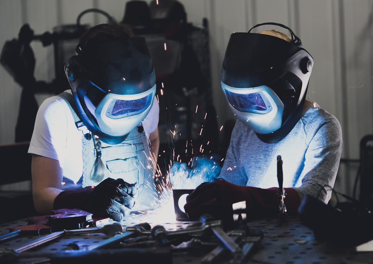 Two People Welding Metal in an Industrial Setting