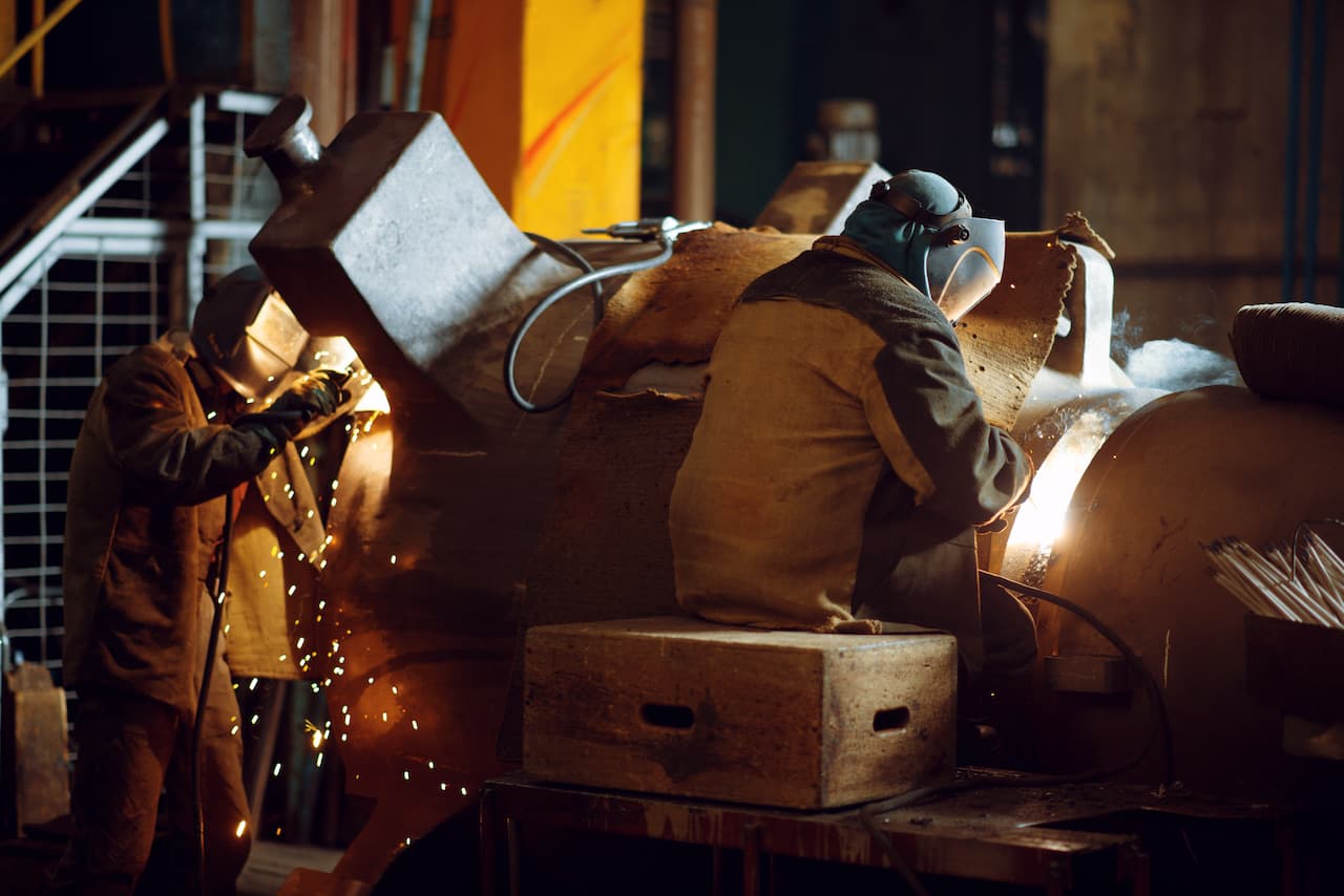 Two welder in masks works with metal, welding
