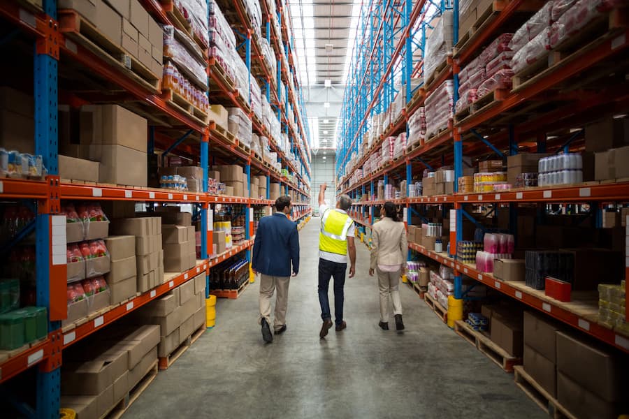 View of distribution coordinators walking and looking up in warehouse