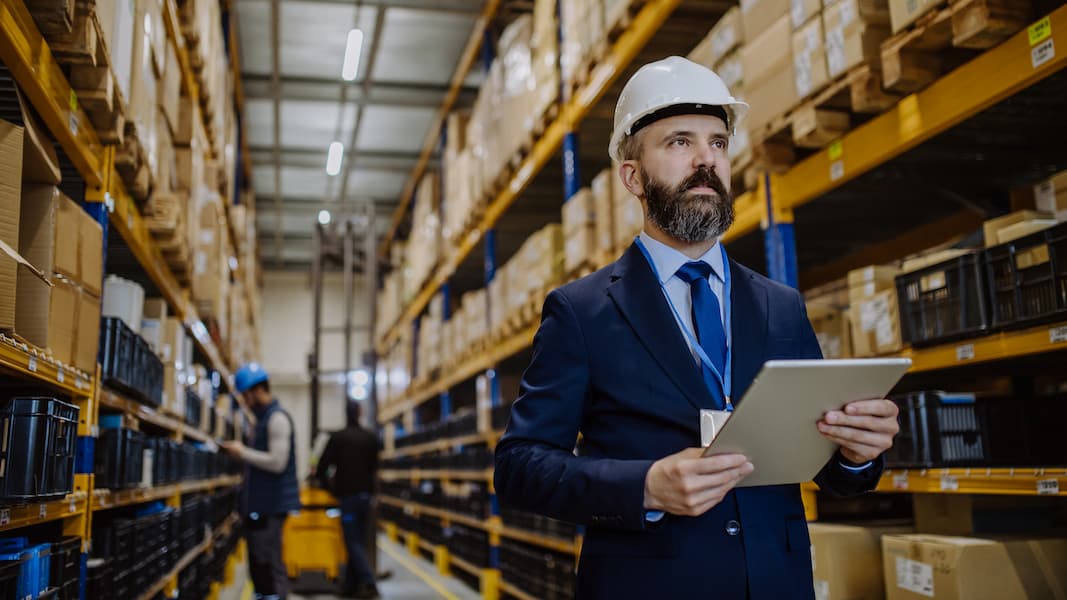 Warehouse Purchasing Manager Inspecting Inventory with a Tablet