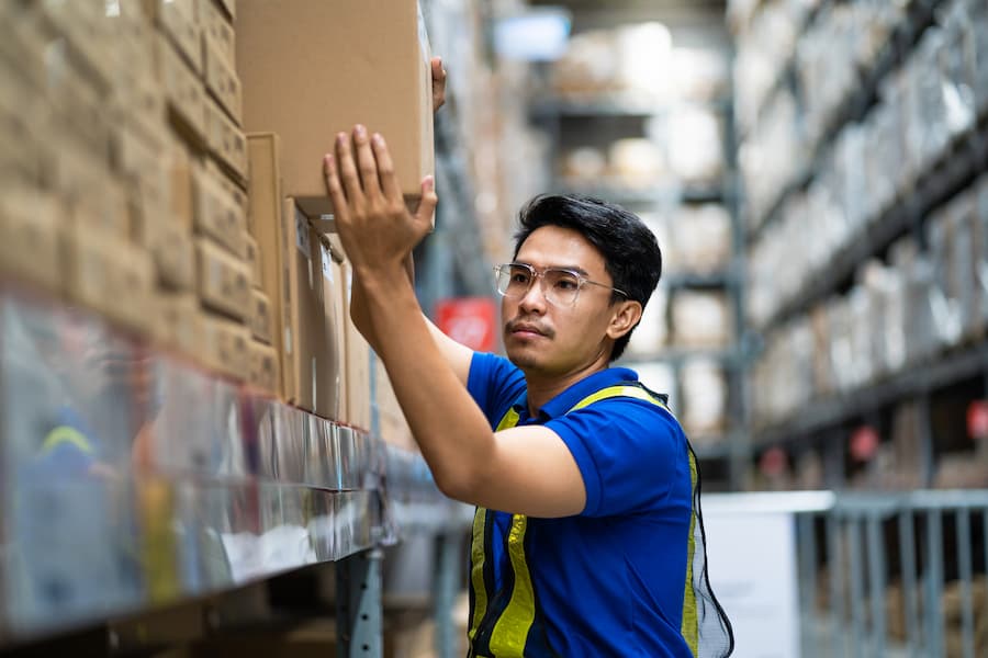 Warehouse Worker Organizing Stock in Distribution Center