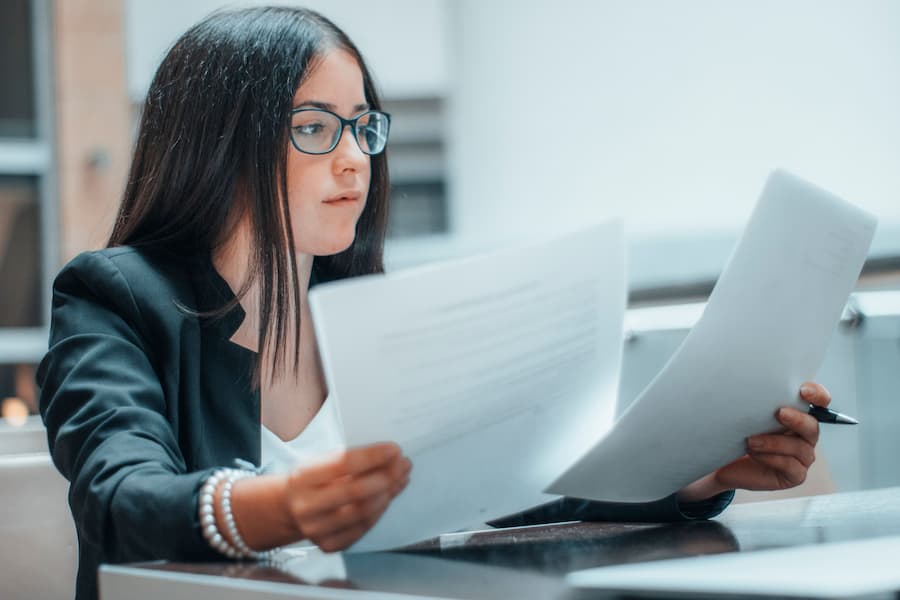 Young businesswoman in glasses and a suit working in an office