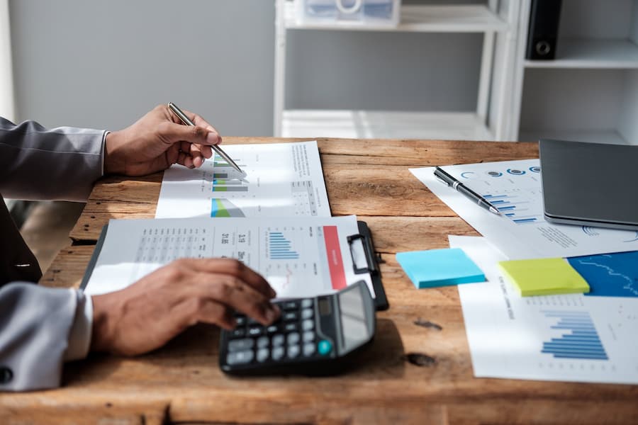An accountant working with financial reports and calculator