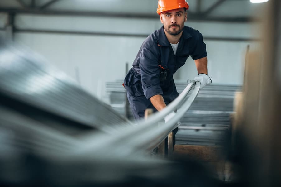 Factory worker moving metal planks in Brisbane factory