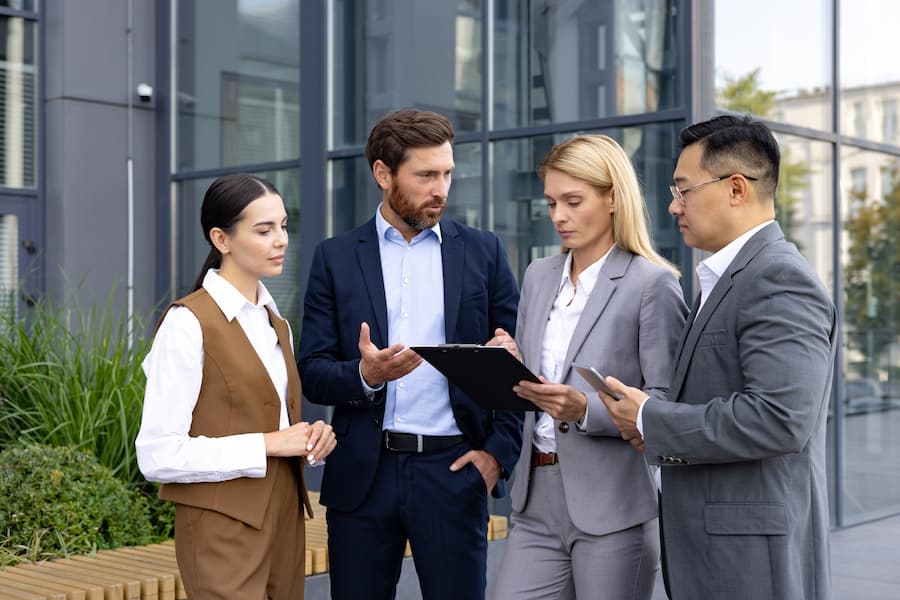 Financial professional discuss over a clipboard outside an office building