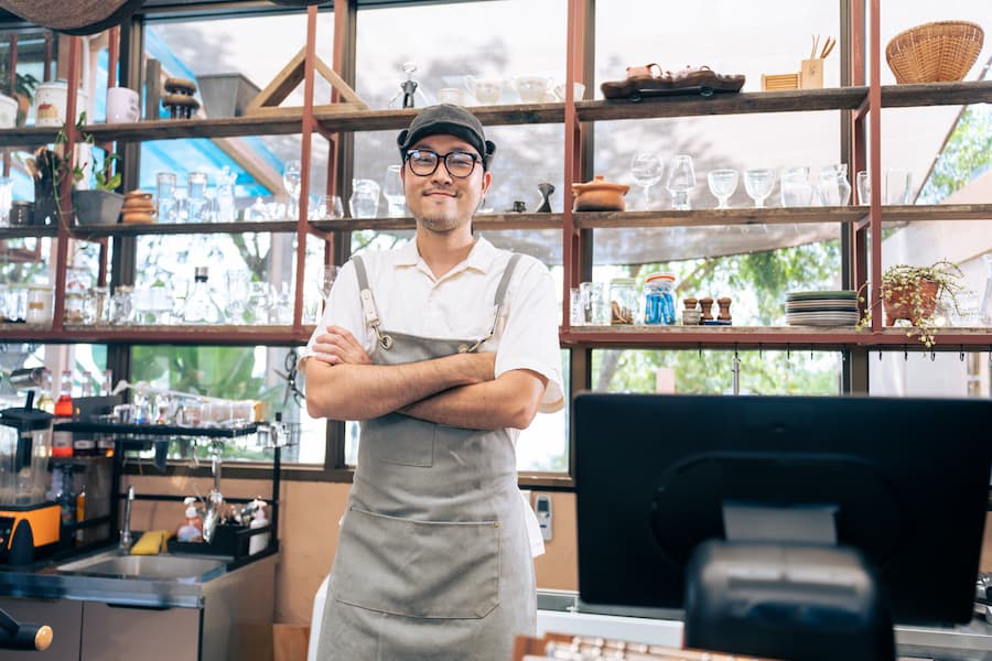 Portrait of Asian male barista or waiter working in coffeehouse shop.