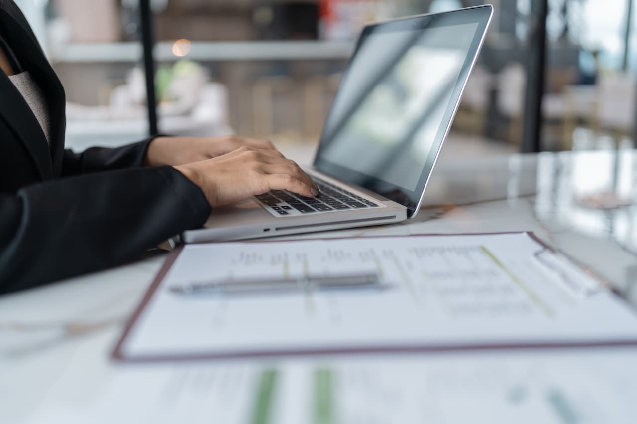 A recruiter working on hiring documentation on laptop