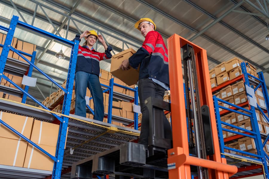 Order picker with the operator elevated collecting a parcel