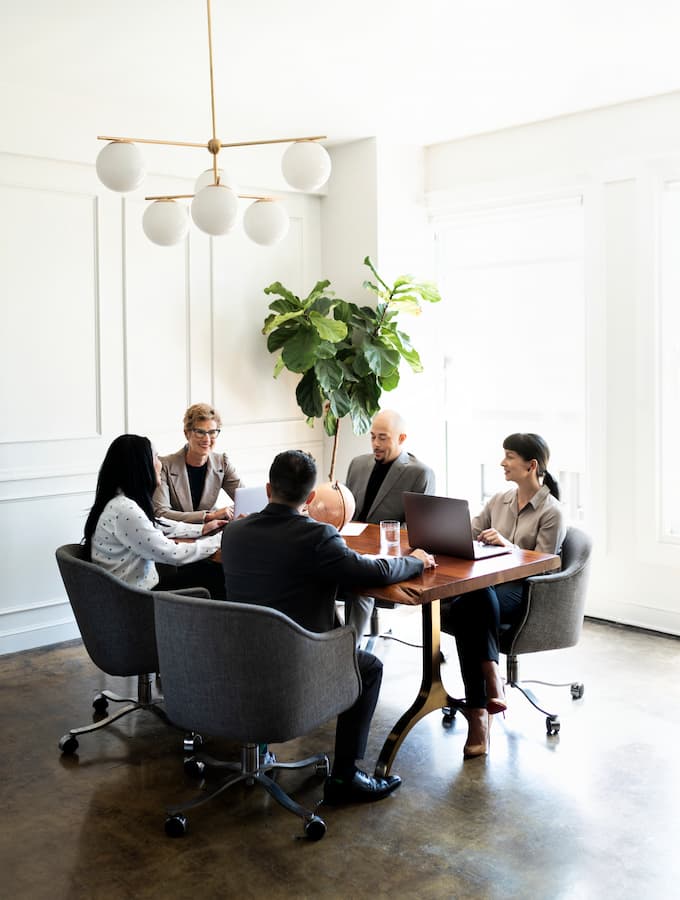 A business meeting at a round table in a sunlight modern office