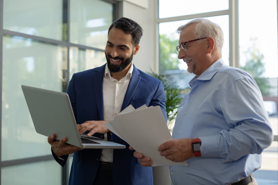 Smiling sales professional look at document together
