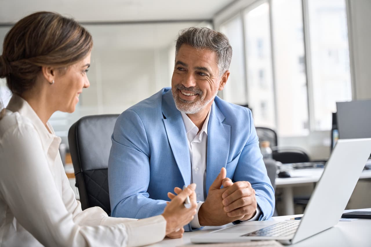 Happy professional bank manager consulting client at office corporate meeting.