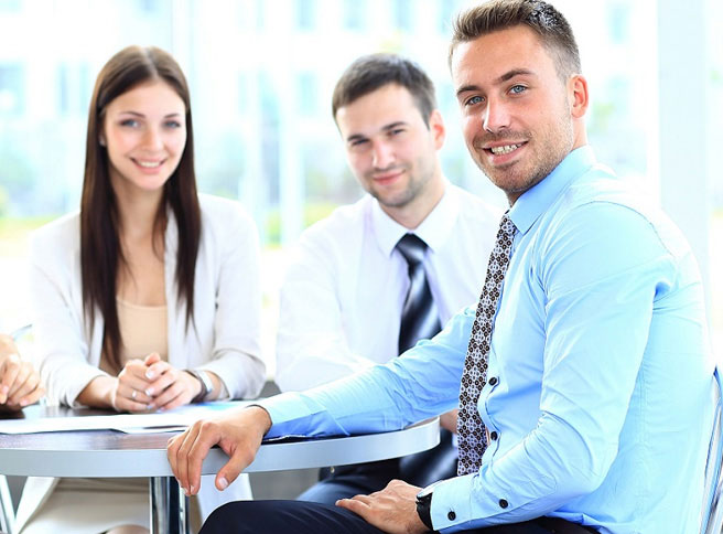 three permanent employees sitting around a table smiling