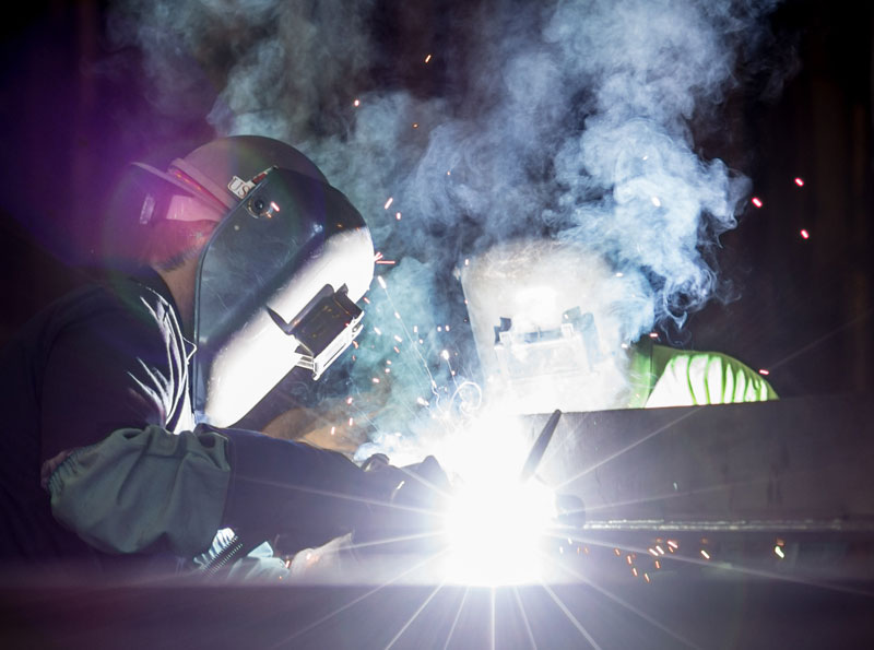 two metal welders with masks and light effects