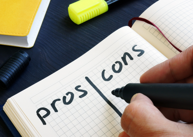 Pros and Cons written on a grid papered notebook